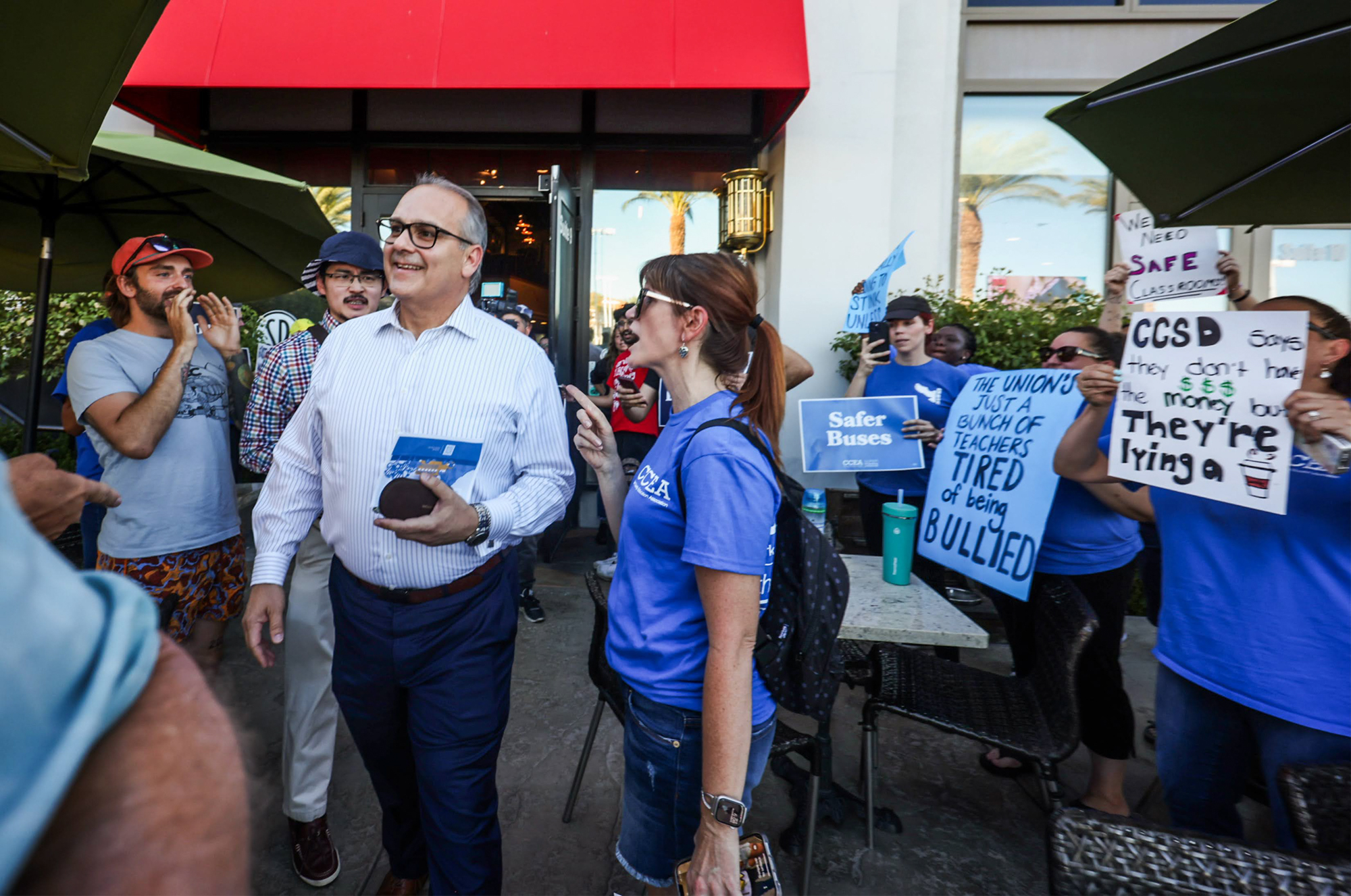 Clark County Education Association protesters antagonize Clark County School District Superintendent Jesus Jara after a meeting he hosted with parents at Sambalatte coffee shop in Summerlin on Tuesday, July 18, 2023. (Jeff Scheid/The Nevada Independent)